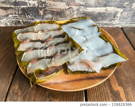 西班牙鯖魚和大鰭礁魷魚用海帶醃製。這道菜是將新鮮的生魚片用海帶包裹並醃製而成。 139828366