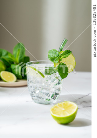 A fresh mojito with lime, mint and ice in glass. Citrus lemonade or cocktail on a marble table 139828481