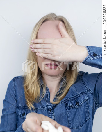 Woman suffering from phagophobia struggling to swallow a pill. Anxious female holding a medicine bottle, feeling fear, stress and difficulty swallowing medication. Woman suffering from phagophobia struggling to swallow a pill. Anxious female holding a medicine bottle, feeling fear, stress and difficulty swallowing medication. 139828822