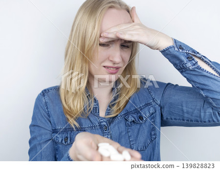 Woman suffering from phagophobia struggling to swallow a pill. Anxious female holding a medicine bottle, feeling fear, stress and difficulty swallowing medication. Woman suffering from phagophobia struggling to swallow a pill. Anxious female holding a medicine bottle, feeling fear, stress and difficulty swallowing medication. 139828823
