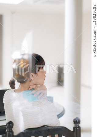 Pensive asian woman sitting quietly inside looking away showing calm emotional expression while wearing white shirt in bright modern room with creative reflection effect on window glass Pensive asian woman sitting quietly inside looking away showing calm emotional expression while wearing white shirt in bright modern room with creative reflection effect on window glass 139829188