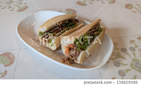Vietnamese pork sandwich with coriander and carrot on a white plate  139829380