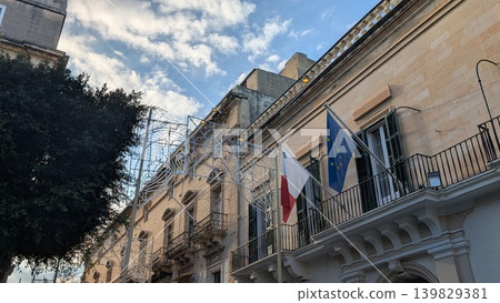 Cityscape with a Maltese flag and a European Union flag and Christmas lights decoration on the street Cityscape with a Maltese flag and a European Union flag and Christmas lights decoration on the street 139829381