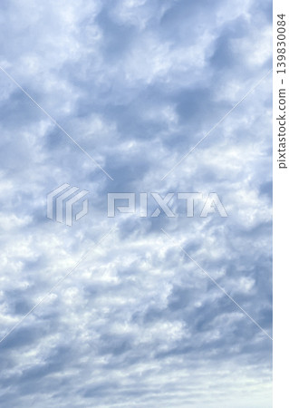 蓬鬆的羊形雲朵散佈在陰雲密佈的天空。 蓬鬆的羊形雲朵散佈在陰雲密佈的天空。 139830084