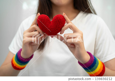 Asian LGBT woman holding heart rainbow flag. Asian LGBT woman holding heart rainbow flag. 139830212