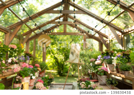 Blurred background of a beautiful wooden greenhouse filled with blooming flowers and potted plants. Blurred background of a beautiful wooden greenhouse filled with blooming flowers and potted plants. 139830438