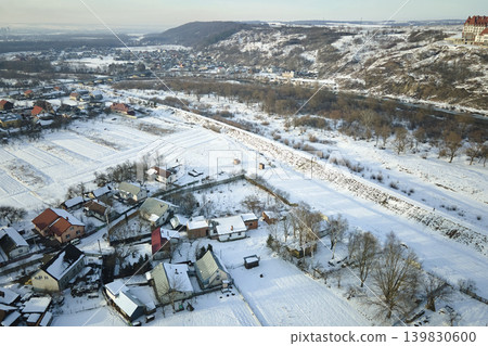 Aerial view of residential houses with snow covered roofops in suburban rural town area in winter Aerial view of residential houses with snow covered roofops in suburban rural town area in winter 139830600