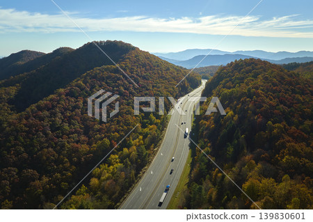 I-40 freeway road leading to Asheville in North Carolina over Appalachian mountain pass with yellow fall forest and fast moving trucks and cars. Concept of high speed interstate transportation 139830601