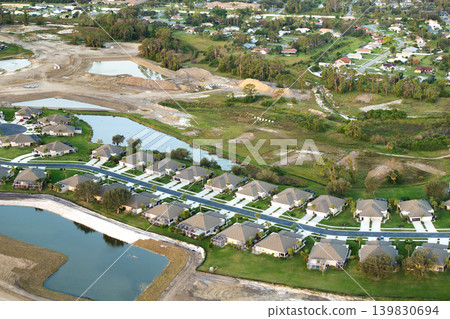 Expensive mansions between green palm trees in southwest Florida suburbs, USA. Aerial view of wealthy residential neighborhood Expensive mansions between green palm trees in southwest Florida suburbs, USA. Aerial view of wealthy residential neighborhood 139830694
