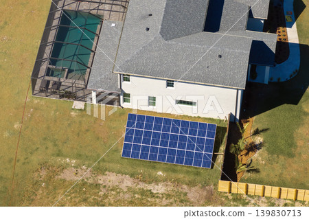 Solar photovoltaic panels mounted on stand-alone frame on backyard ground for generating of clean ecological electric energy Solar photovoltaic panels mounted on stand-alone frame on backyard ground for generating of clean ecological electric energy 139830713
