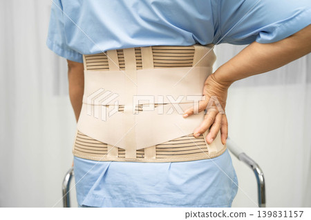 Asian senior pain back wearing elastic support belt with walker. Asian senior pain back wearing elastic support belt with walker. 139831157