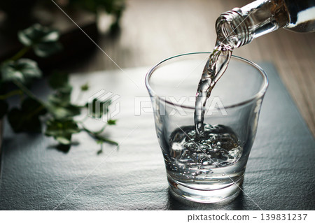 將礦泉水倒入玻璃杯中 將礦泉水倒入玻璃杯中 139831237