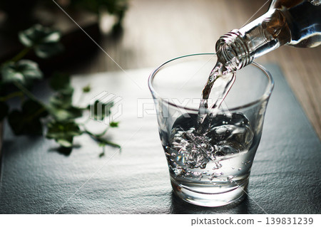 將礦泉水倒入玻璃杯中 將礦泉水倒入玻璃杯中 139831239
