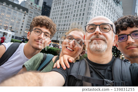 New york, usa august 19,2024. Family group taking a joyful selfie in manhattan, smiling together outdoors with iconic urban buildings and sunny city vibes 139831255
