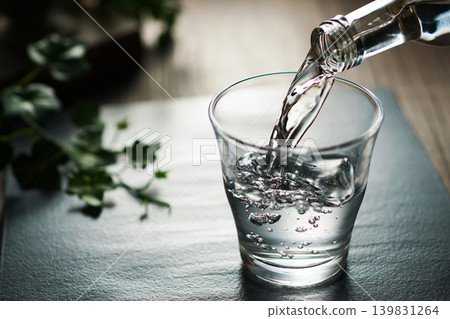 將礦泉水倒入玻璃杯中 將礦泉水倒入玻璃杯中 139831264