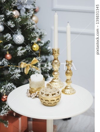 New Year's decorations on the table, candles in gold candlesticks, a box New Year's decorations on the table, candles in gold candlesticks, a box 139831345