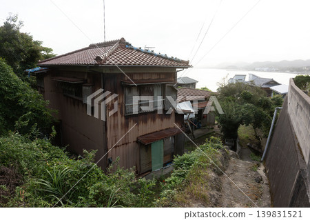 A sloping street where the sea breeze blows: A nostalgic old wooden house on the Boso Peninsula with a view of the sea in the distance. 139831521