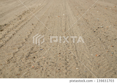 Dry sandy road surface texture with faint tire tracks close up, country dirt path in countryside outdoor travel background Dry sandy road surface texture with faint tire tracks close up, country dirt path in countryside outdoor travel background 139831703