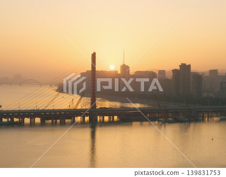 Aerial view of Hangzhou Qiantang river bridge at golden hour sunset with city skyline Aerial view of Hangzhou Qiantang river bridge at golden hour sunset with city skyline 139831753