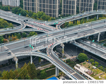 Multilevel highway interchange with numerous vehicles traversing elevated roads and ramps in a dense city environment Multilevel highway interchange with numerous vehicles traversing elevated roads and ramps in a dense city environment 139831789