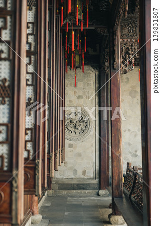 A traditional Chinese building displays ornate wooden pillars and intricate lattice screens in Deshou Palace in Hangzhou, China 139831807