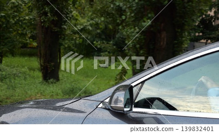 Modern electrical automobile driving at urban road on rainy day. Ecology friendly car riding moving along motorway. Electric vehicle riding through empty highway. Concept of green innovation. Slow mo Modern electrical automobile driving at urban road on rainy day. Ecology friendly car riding moving along motorway. Electric vehicle riding through empty highway. Concept of green innovation. Slow mo 139832401
