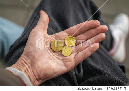 Hand holding euro cent coins on dark clothing, showing 10, 20, 50 cent coins in palm. Concept of coins for payment, savings, budgeting, donation, poverty, finance, retirement, money management Hand holding euro cent coins on dark clothing, showing 10, 20, 50 cent coins in palm. Concept of coins for payment, savings, budgeting, donation, poverty, finance, retirement, money management 139832745