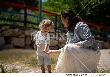 Mother and son enjoying a sunny day together at a children's park sharing a joyful moment 139832845