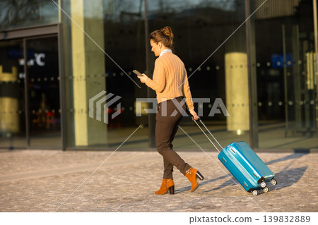 Professional Traveler Checking Phone while Walking at Station Professional Traveler Checking Phone while Walking at Station 139832889