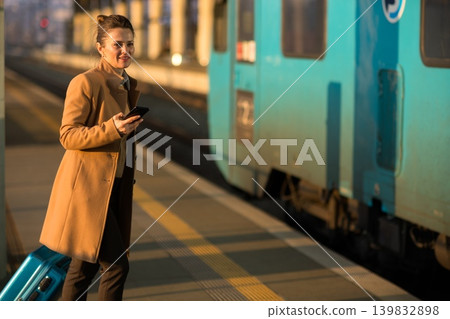 Woman Waiting for Train Departure with Teal Suitcase Woman Waiting for Train Departure with Teal Suitcase 139832898