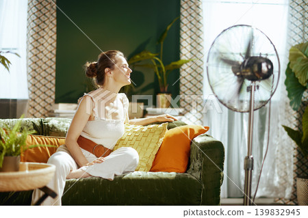Smiling Woman Blissfully Enjoying Fan\'s Breeze 139832945