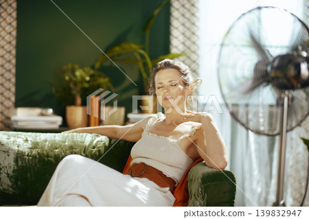 Serene Woman Enjoying Fan Breeze at Home 139832947