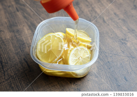 Lemon slices and honey in a Tupperware container Lemon slices and honey in a Tupperware container 139833016
