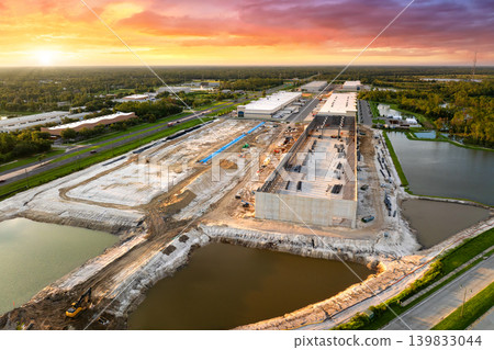 Assembling of metal and concrete frame building at industrial construction site. Commercial real estate market in the USA Assembling of metal and concrete frame building at industrial construction site. Commercial real estate market in the USA 139833044