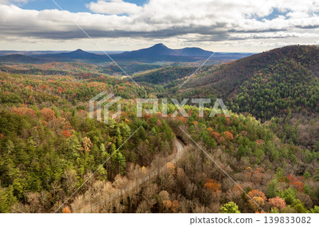 Car cruising on scenic road in Appalachian mountains at sunset. Trees glowing in vibrant fall foliage as the sun sets Car cruising on scenic road in Appalachian mountains at sunset. Trees glowing in vibrant fall foliage as the sun sets 139833082