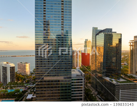 Miami, coastal city in Florida at sunset. Waterfront skyscraper buildings in downtown district of USA urban area. American megapolis with business financial district Miami, coastal city in Florida at sunset. Waterfront skyscraper buildings in downtown district of USA urban area. American megapolis with business financial district 139833143