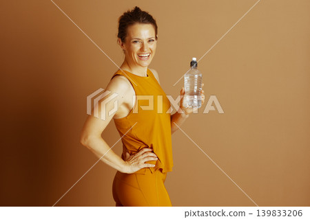 Cheerful Woman in Yellow Activewear Hydrating Cheerful Woman in Yellow Activewear Hydrating 139833206
