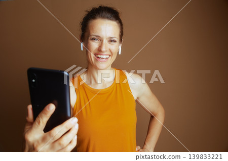 Confident Woman with Phone and Earbuds Confident Woman with Phone and Earbuds 139833221