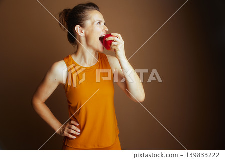 Woman Bites Red Apple with Joyful Focus 139833222