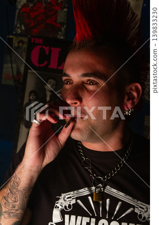 Alternative punk man smoking cigarette with red mohawk haircut 139833230
