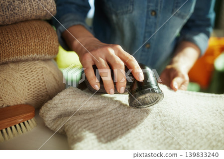 Removing Pills from a Winter Coat with a Fabric Shaver 139833240