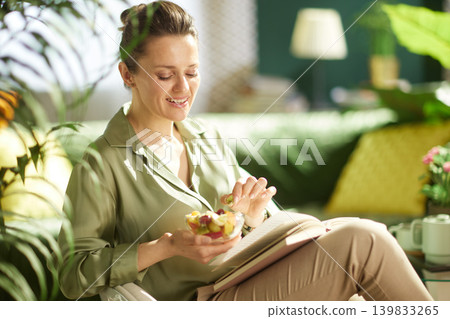 Smiling Woman Enjoying a Healthy Fruit Snack Break Smiling Woman Enjoying a Healthy Fruit Snack Break 139833265