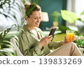 Modern Woman Enjoying Morning Juice and Phone at Home 139833269