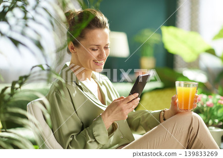 Modern Woman Enjoying Morning Juice and Phone at Home Modern Woman Enjoying Morning Juice and Phone at Home 139833269