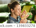 Woman Taking a Bite of Savory Pizza at Home 139833278
