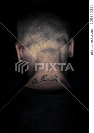 Young skinhead with his back turned, showing an ACAB (all cops are bastard) tattoo Young skinhead with his back turned, showing an ACAB (all cops are bastard) tattoo 139833333