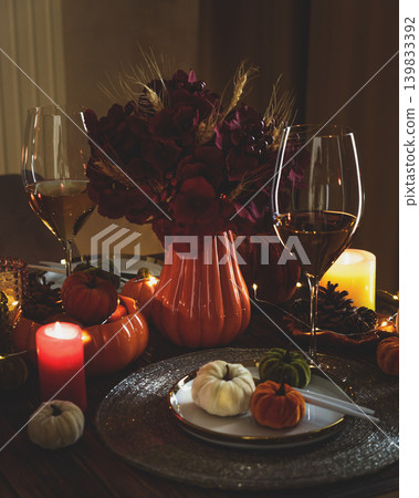 Thanksgiving table setting with decorative pumpkins, candles and string lights Thanksgiving table setting with decorative pumpkins, candles and string lights 139833392