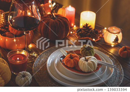 Autumnal table setting with decorative pumpkins, candles and string lights. Autumnal table setting with decorative pumpkins, candles and string lights. 139833394