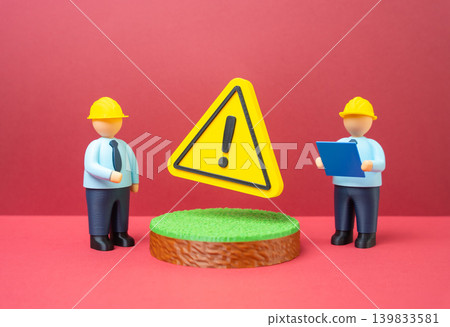 Engineers in hard hats and with drawings discuss pre construction issues. Soil surveys, underground utilities, permits and infrastructure planning before development. 139833581