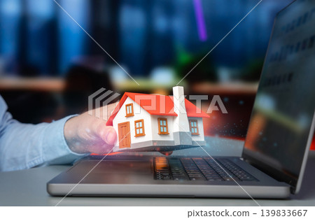 A house in a man's hand symbolizing homeownership and property investment. Buying and selling real estate, smart home technology, construction and architectural design. A house in a man's hand symbolizing homeownership and property investment. Buying and selling real estate, smart home technology, construction and architectural design. 139833667